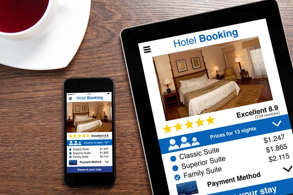 Tableta de ordenador y teléfono táctil con pantalla de reserva de hotel aplicación —  Fotos de Stock