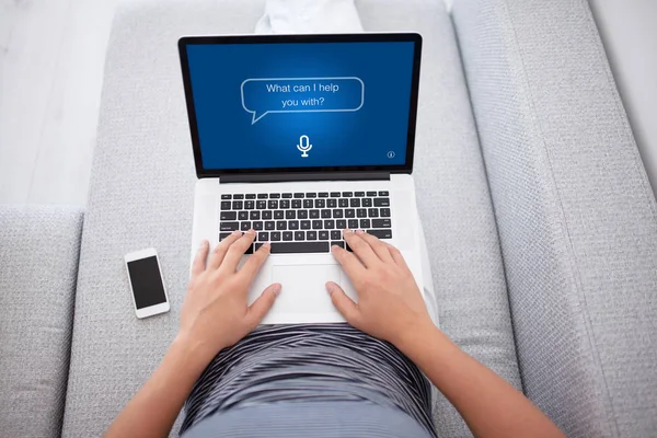 Adam kanepede app kişisel asistan ekranlı dizüstü bilgisayar yazmaya — Stok fotoğraf