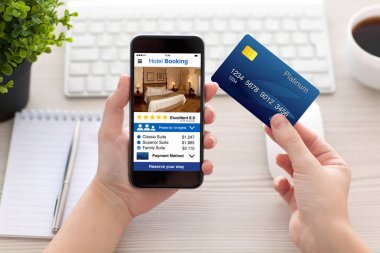 telefon app otel rezervasyonu ve kredi kartı tutan eller