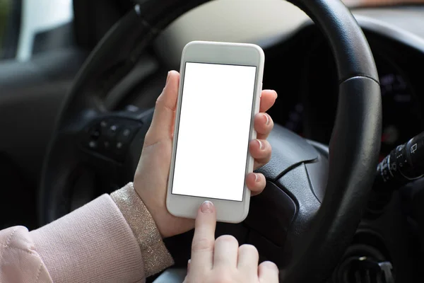 Mãos femininas segurando telefone com tela isolada atrás do carro da roda — Fotografia de Stock