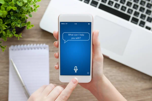 Mano femminile che tiene il telefono bianco con app personal assistant scre — Foto Stock