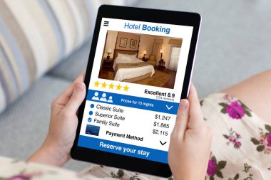 çiçekli elbise holding tablet app otel rezervasyonu ile kadında