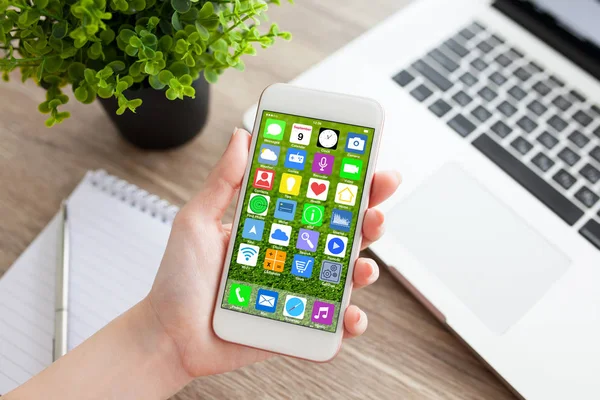 Handen van de vrouw met telefoon met beginscherm pictogrammen apps notebook — Stockfoto