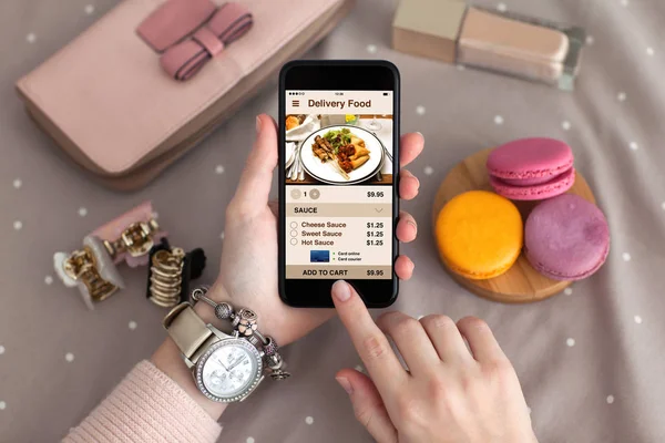Mão feminina com jóias segurando telefone com entrega de aplicativos comida — Fotografia de Stock