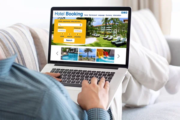 Man in room holding laptop with online search booking hotel — Stock Photo, Image