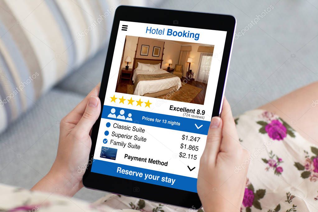 woman in flowered dress holding tablet with app hotel booking