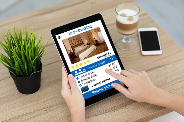 Tableta de computadora de mano mujer con pantalla de reserva de hotel de aplicación —  Fotos de Stock