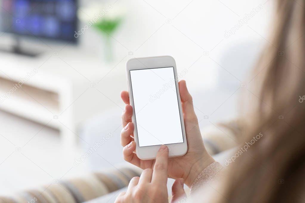 Female hands holding phone with isolated screen in  room