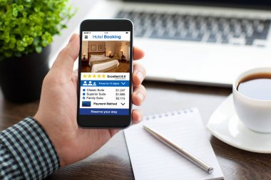 telefon ile app otel rezervasyon perde ofiste tutan adam