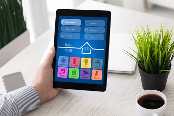 Mann hält Computer-Tablet mit App Smart Home-Bildschirm in der Hand — Stockfoto