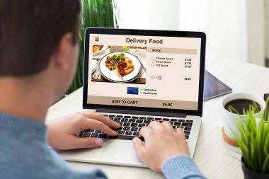 adam dizüstü bilgisayar ile teslimat yemek odasında ekranda