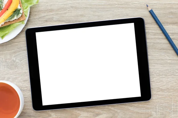 Computer tablet with an isolated screen on wooden table — Stock Photo, Image