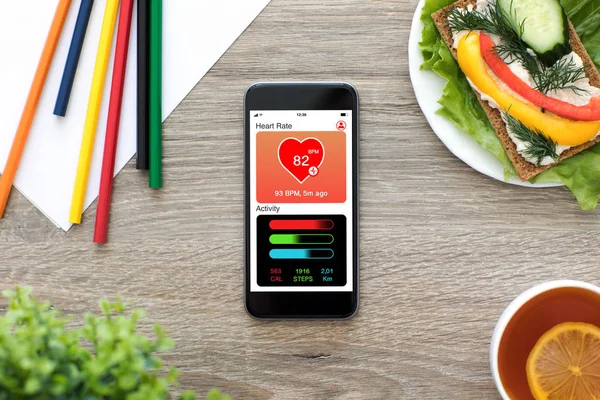 Phone with app health tracking activity screen on wooden table — Stock Photo, Image