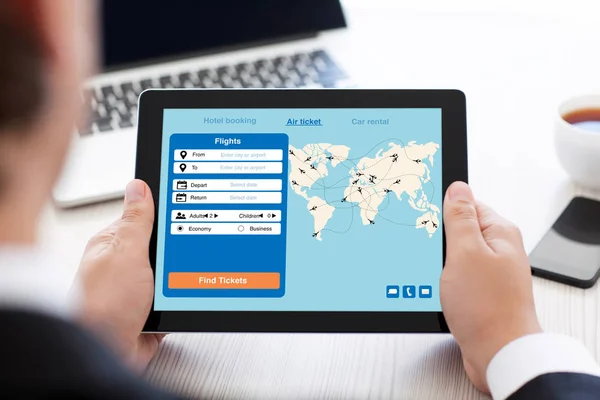 Muž hospodářství tablet s aplikací Hledat letenky na obrazovce — Stock fotografie