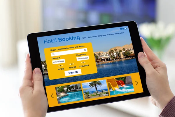 Manos femeninas sosteniendo la tableta con la aplicación de reserva de hotel en pantalla — Foto de Stock