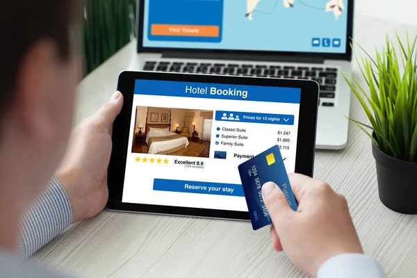 人控股平板电脑与 app 酒店预订屏幕信用卡 — 图库照片