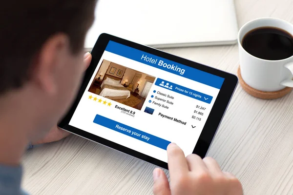 男子手持平板电脑应用程序酒店预订在屏幕上 — 图库照片