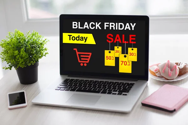 Laptop with sale black friday on screen and phone — Stock Photo, Image
