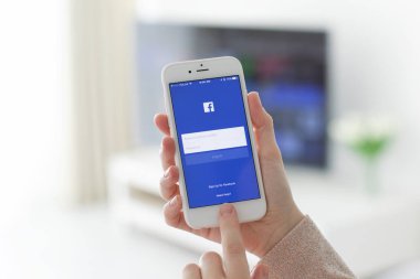 Kadın el iPhone sosyal ağ hizmeti Faceboo ile tutarak