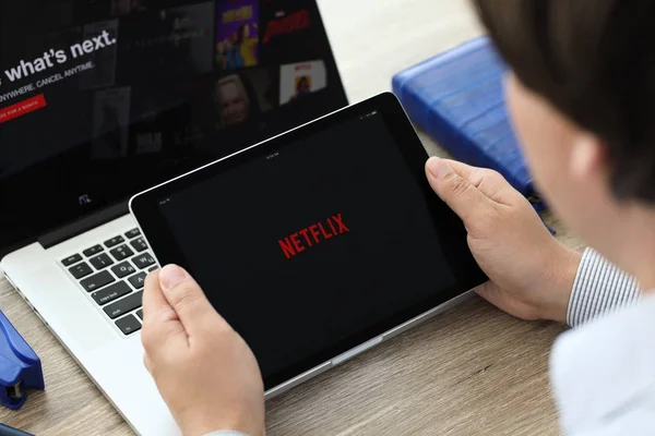 Человек, держащий iPad Pro с Netflix, предоставляет потоковые медиа — стоковое фото