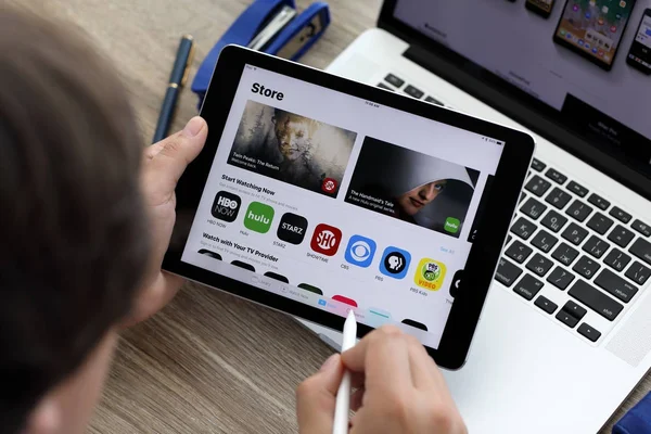 Main d'homme tenant iPad et MacBook avec App Store à l'écran — Photo