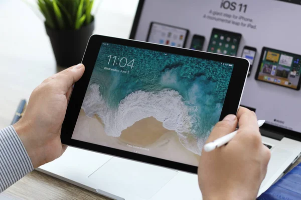 Man hand holding iPad Pro with IOS 11 on the screen — Stock Photo, Image