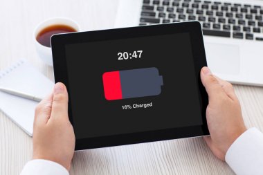 Tablet düşük şarj edilmiş bir batarya ile ekranda holding erkek eller 