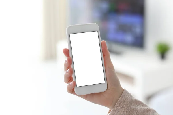 Manos femeninas sosteniendo teléfono blanco con pantalla aislada en la habitación —  Fotos de Stock