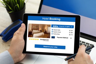 adam holding tablet ile app otel rezervasyonu ekranda