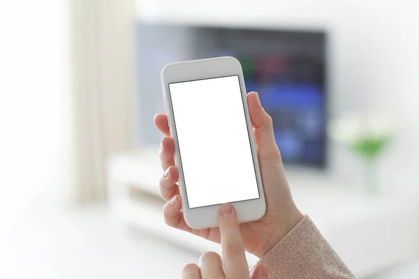 Manos femeninas sosteniendo teléfono blanco con pantalla aislada en la habitación —  Fotos de Stock