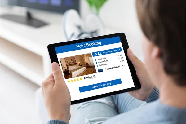 Man holding computer tablet with app hotel booking on screen — Stock Photo, Image