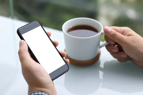 Homens mãos segurando telefone com tela isolada e chá de xícara — Fotografia de Stock