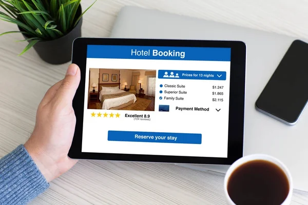 Hombre de la mano de la tableta de ordenador con pantalla de reserva de hotel aplicación — Foto de Stock