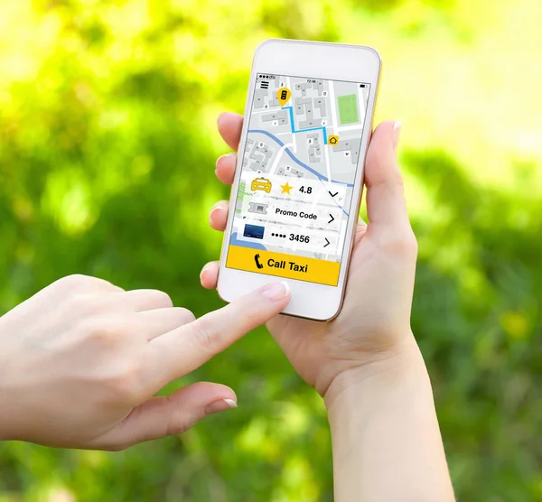 Female hands holding white phone with app call taxi screen — Stock Photo, Image