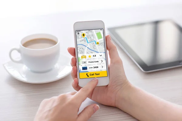 Kvinnor händer håller vita telefonen med appen ringa taxi skärmen — Stockfoto