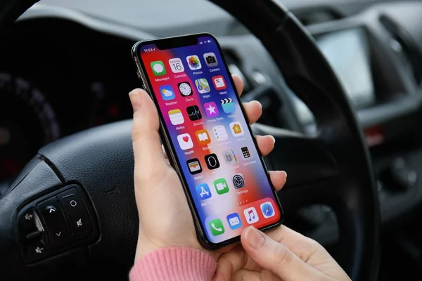 Mano de mujer sosteniendo iPhone X con IOS 11 en el coche — Foto de Stock