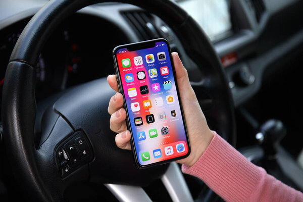Woman hand holding iPhone X with IOS 11 in car