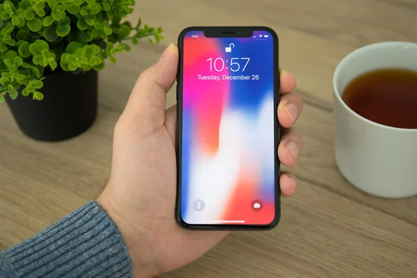 Man hand holding iPhone X with IOS 11 on screen — Stok Foto