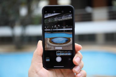 Fotoğraf makinesi ekranında ile iPhone X tutan adam el