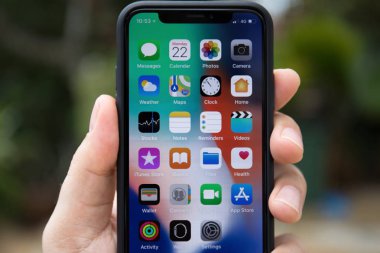 Ekran üzerinde IOS 11 ile X iPhone tutan adam el