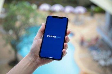 Kadın el iPhone X uygulama Booking.com online otel tutarak