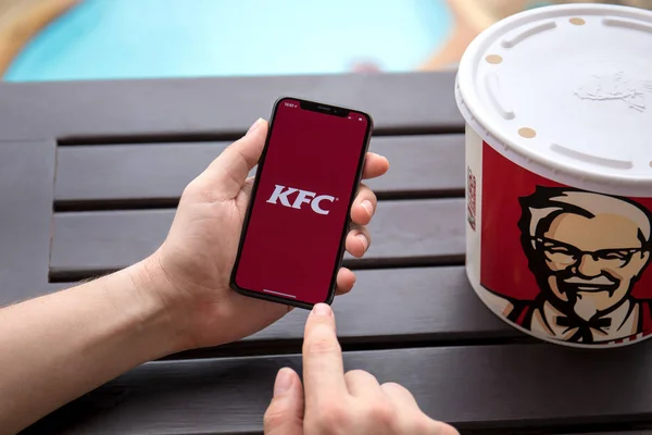 Mann hält iphone x mit app kentucky gebratenes Huhn — Stockfoto