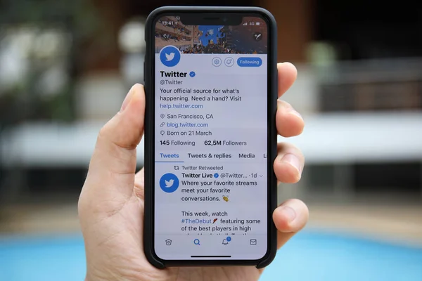 Homem mão segurando iPhone X com serviço de redes sociais Twitter — Fotografia de Stock