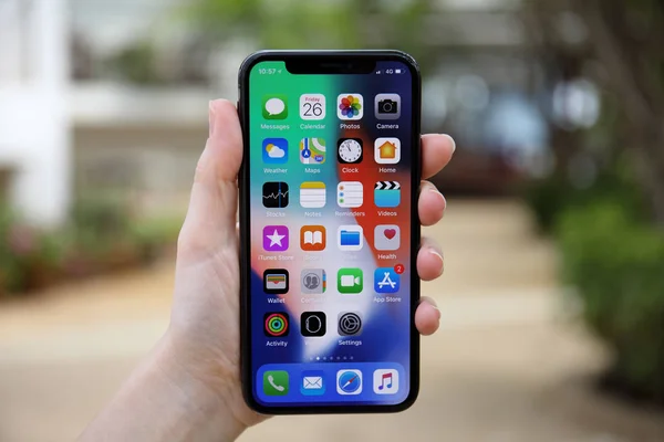 Woman hand holding iPhone X with IOS 11 on screen — Stock Photo, Image