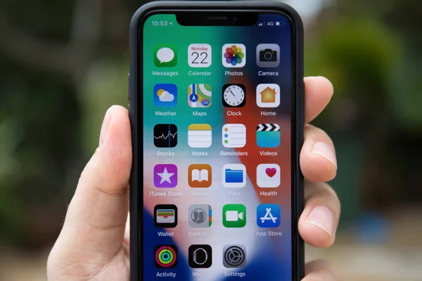 Man hand holding iPhone X with IOS 11 on screen — Stock Photo, Image