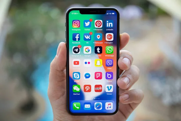 Mann hält iphone x mit sozialem Netzwerk auf dem Bildschirm — Stockfoto