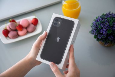 Kadın el ele tutuşma kutusu Apple iPhone 11 masanın altında