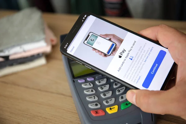 Man hand gospodarstwa Apple iphone 11 pay pass terminalu online — Zdjęcie stockowe