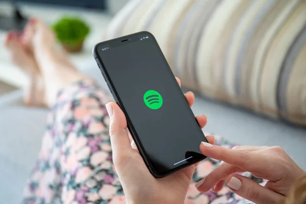 Femme tenant iPhone 11 avec service de musique Spotify à l'écran . — Photo