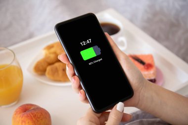 Ekranda şarjlı pille telefonu tutan kadın elleri 